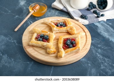 Board With Danish Pastry On Color Background