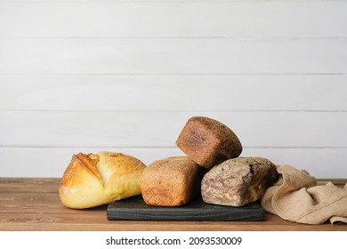 Board with different fresh bread on table