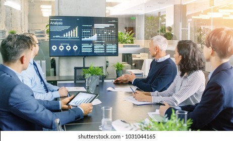 Board Of Directors Has Annual Meeting, Diverse Group Of Business People In The Modern Conference Room Discuss Statistics And Work Results. In The Background Projector Showing Company Growth.