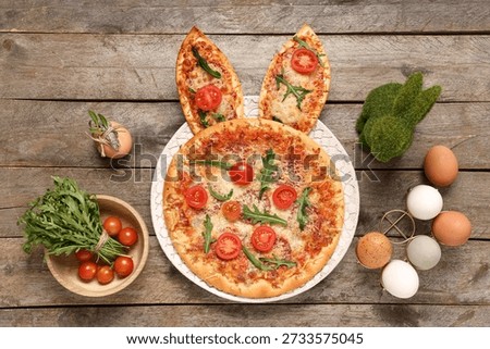 Board of Easter pizza with bunny ears on wooden background