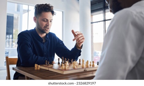 Board game, chess and men playing at a table while talking strategy or plan. Business partners or friends together to play, relax and bond with wooden icon for problem solving, challenge or checkmate - Powered by Shutterstock