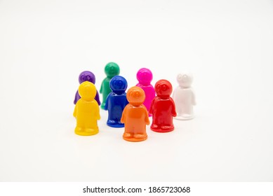 Board Game Colorful Plastic Figures Stand In A Crowd On A Light Background. A Symbol Of A Crowd Of People, A Work Team, A Business Metaphor.