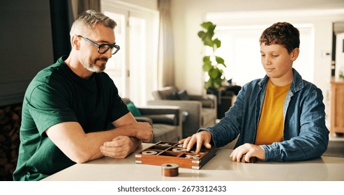 Board game, development or learning with father and son playing tic tac toe in home together. Fun, strategy or thinking with boy child and parent man in apartment for noughts and crosses contest