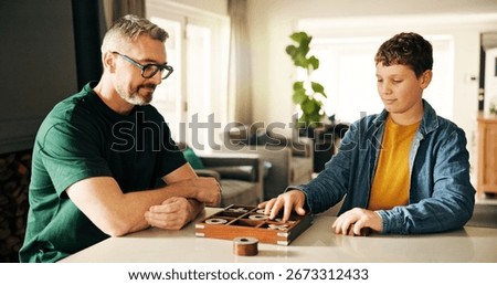 Board game, development or learning with father and son playing tic tac toe in home together. Fun, strategy or thinking with boy child and parent man in apartment for noughts and crosses contest