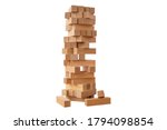 Board game Jenga Tower made of wooden blocks. A tower of unevenly shifted wooden beams. A lesson for agility, logic and coordination. Home entertainment. Balance. Close-up. Isolation, white background