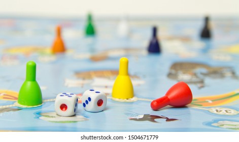 Board games for the home. Colored plastic chips and dice on the background of board games . Selective focus