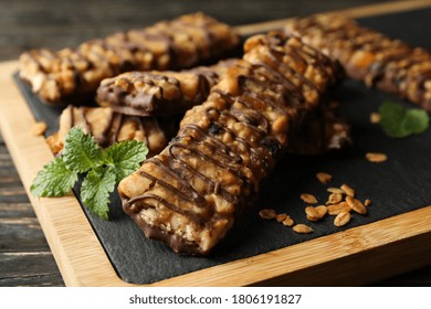 Board with granola bars on wooden background, close up - Powered by Shutterstock