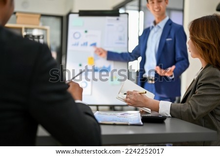 Board members are in the meeting while a professional and smart millennial Asian businessman pitching or presenting his new financial investment strategy.