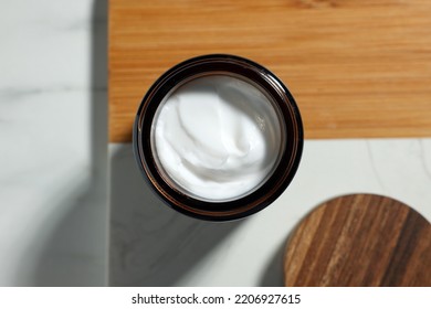 Board With Open Jar Of Cosmetic Cream On White Table, Top View