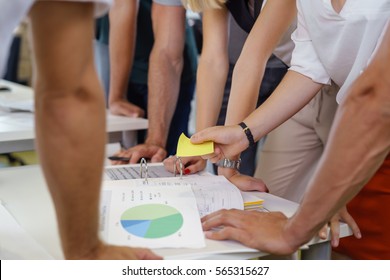 Board Room Executives Stand Around Meeting Table With All Hands Placed On The Table Top