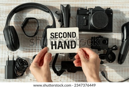 A board with "second hand" text, shown on an old unfolded technique. The concept of using old electrical appliances.