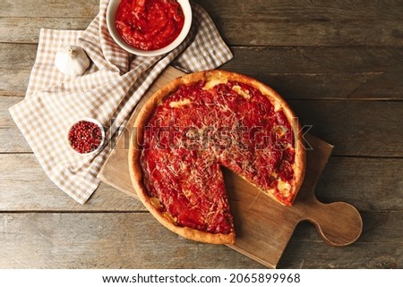 Board with tasty Chicago-style pizza and ingredients on wooden background Stock photo © 