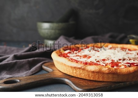 Board with tasty Chicago-style pizza on dark background Stock photo © 