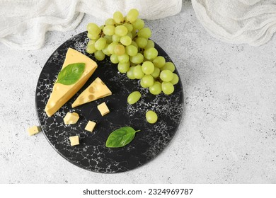 Board with tasty Swiss cheese and grapes on light background - Powered by Shutterstock