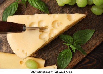 Board with tasty Swiss cheese on table - Powered by Shutterstock