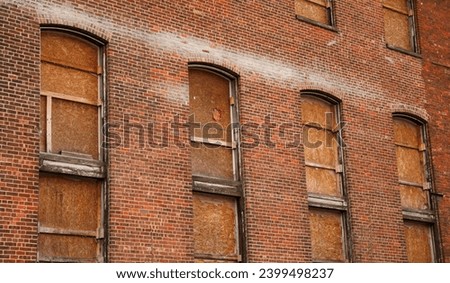 Boarded windows on urban buildings as precaution against riots, symbolizing protection and societal unrest, evoking a sense of caution and resilience