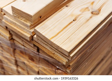 Boards In The Warehouse Of The Wholesale Store. Pine Lumber Prepared For Delivery To The Construction Site. Trade In Processed Timber In Large And Small Quantities. Close-up