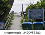 Boardwalk entrance for Cape Canaveral beach with trash bins to help keep the beach clean.