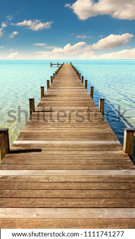 boardwalk to the horizon, turquoise water and blue sky with clouds, paradise landscape