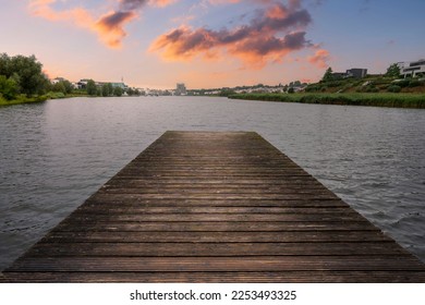 A boardwalk leading to a scenic waterscape during a sunset - Shutterstock ID 2253493325