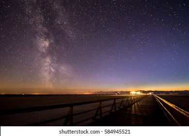 Boardwalk and the Milky Way on a beach of Sankt Peter Ording, North Sea in Germany