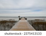 Boardwalk over marsh going to a pier at Lake Waccamaw state park in fall