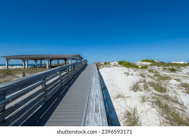 the boardwalk to the pier at St. Andrews State Park, see the pier through the pavilion. - Powered by Shutterstock