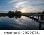 Boardwalk and sunrise cloudscape over constructed wetlands of Green Cay Nature Center in Boynton Beach, Florida..