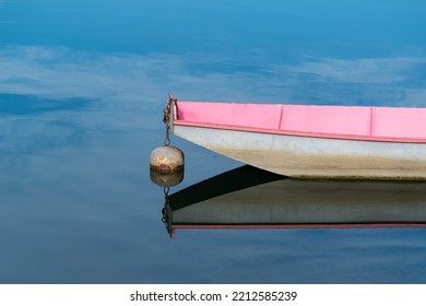 Boat Bow Isolated In Blue Water, Reflection In Still Water