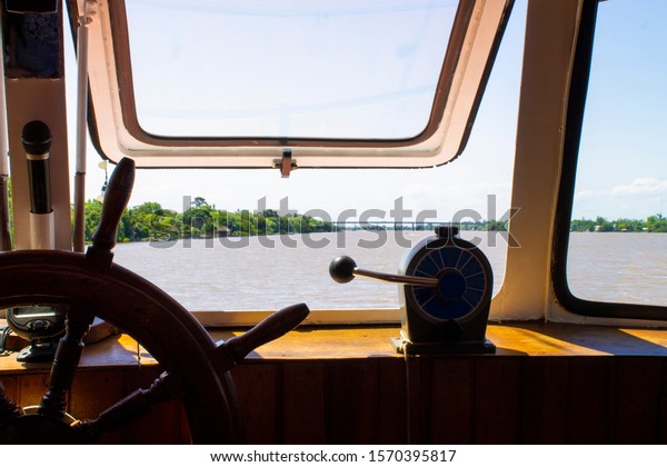 Boat cabin view, boat helm closeup. Boat trip by\
the Guaiba river.