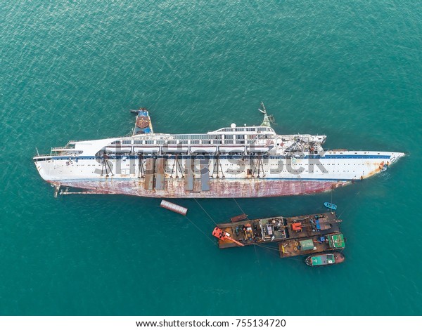 Boat crashes in the sea, cruise ship\
,accident ,Ship wreck.disaster of the passenger vessel capsize and\
sunk into the sea ocean at sunset in aerial view\
