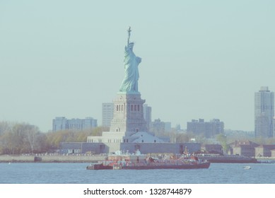 Boat crossing Hudson River in front of Statue of Liberty in New York, USA. Low contrast color image.