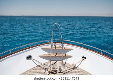 Boat deck. Wide angle view of the yacht front with metal handrails opposite blue sea