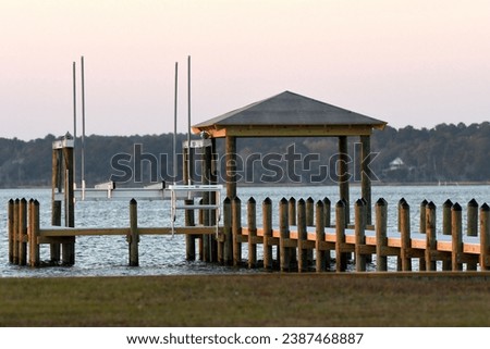 A boat dock and boardwalk on the sound side of an island in the last minutes of daylight. 