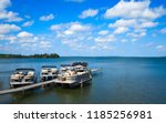 Boat dock with raised pontoons on beautiful lake in northern Minnesota with blue sky and fluffy clouds