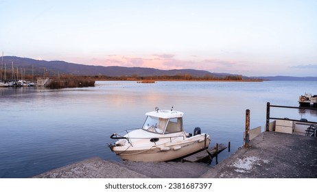 A boat docked on a in a tranquil lake during a beautiful sunset - Powered by Shutterstock