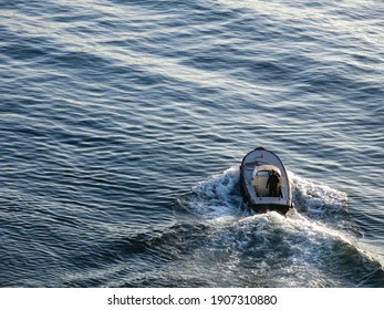 Boat And Driver Full Speed Ahead Breaking Waves Through The Ocean Waters.