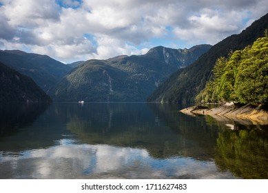 boat in dusky sound. reflection of mountains - Shutterstock ID 1711627483