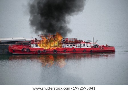 Boat in flames. Fire on board a ship pushing barges.