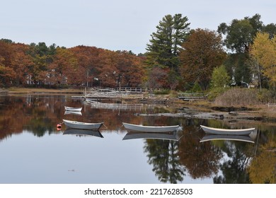 Boat And Foliage Reflections In The Kennebunk River In Maine.