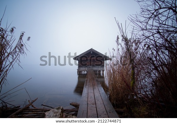 boat house on the lake in\
the fog