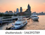 Boat in Huangpu River with Shanghai urban architecture at sunset in dock