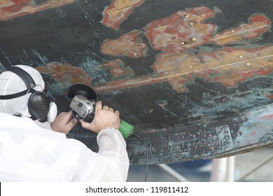 Boat Hull repairs/ a large wooden boat's hull getting sanded in preparation for anti foul paint being applied