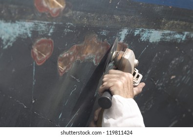 Boat Hull repairs/ a large wooden boat's hull getting sanded in preparation for anti foul paint being applied