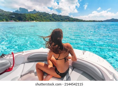 Boat life. Luxury yacht woman enjoying freedom on deck in the wind relaxing on high end boat summer vacation trip. Lifestyle of young rich people. Elegant black bikini, long hair and sun tanned body