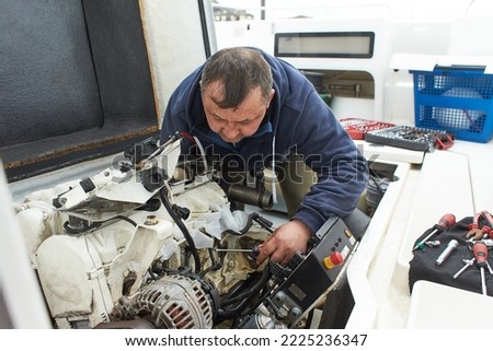 Boat mechanic repairing a ship engine