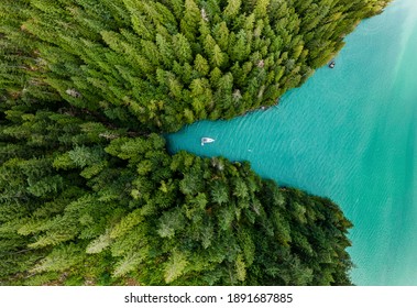 Barco amarrado en una cala con bosques verdes alrededor de la vista aérea