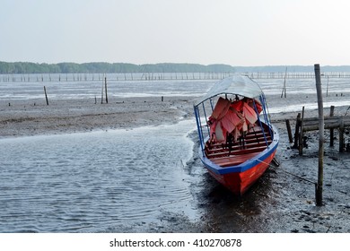 Boat Moored At The Pier During Low Tide In Evening Day