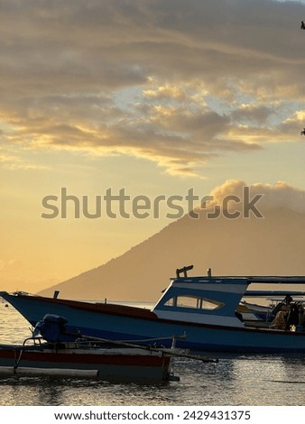 Boat with mountain view in Bunaken Island during sunset