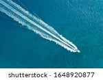 The boat is moving at high speed on the sea. A long Wake follows the boat. Blurred movement. Shooting from a drone.